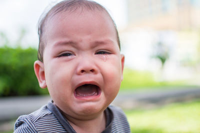 Close-up portrait of cute baby boy crying