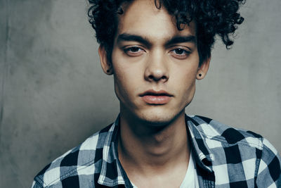 Portrait of young man against wall