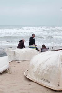 Rear view of people sitting on beach