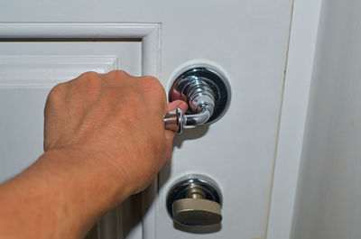 Close-up of hand holding metal door