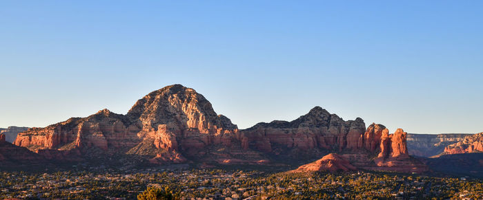 Panoramic view of rocky mountains against clear blue sky