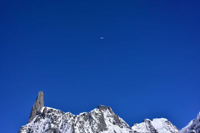 Airplane overflying the snow capped peak of mont blanc in the alps between italy and france