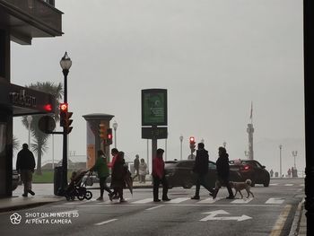 Group of people walking on road in city