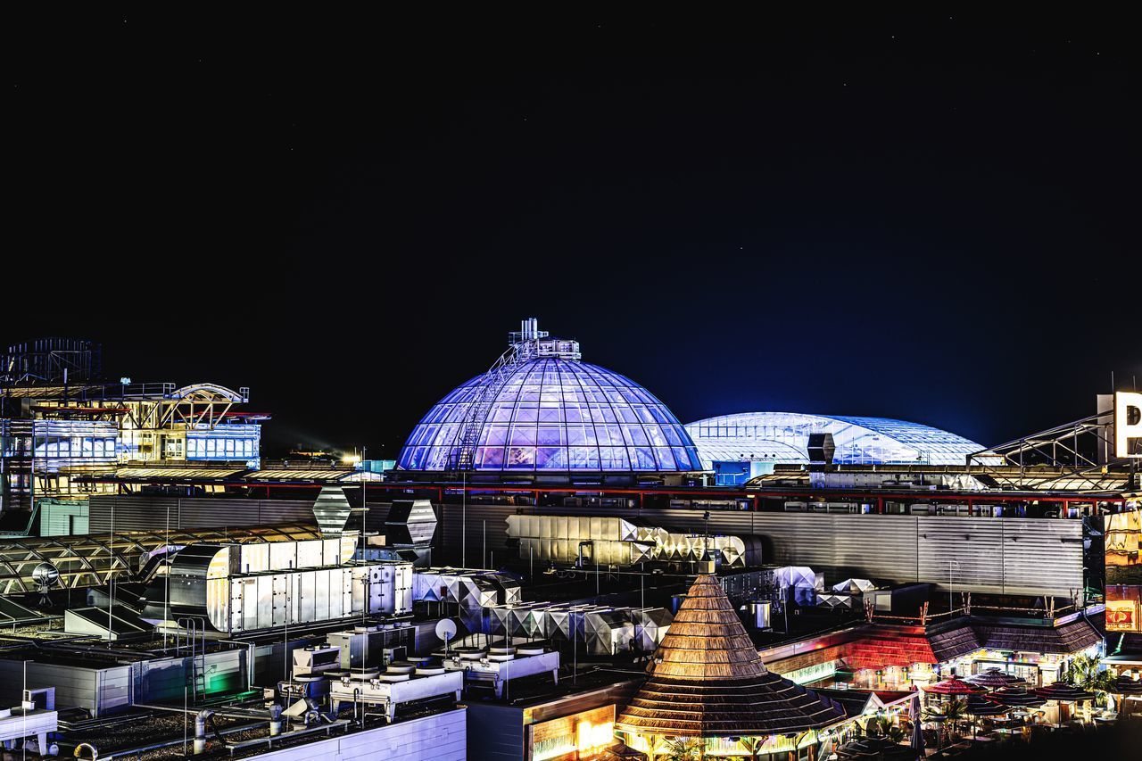 ILLUMINATED BUILDINGS IN CITY AGAINST SKY