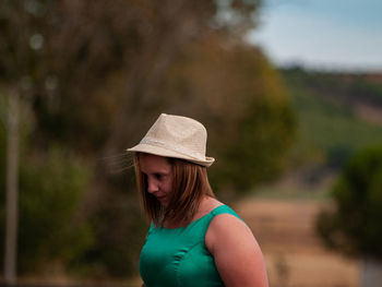 Overweight woman wearing hat while standing outdoors