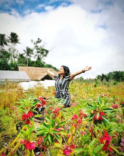 Full length of woman standing by flowering plants