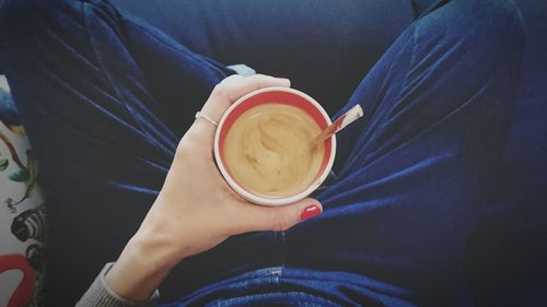 Midsection of woman holding coffee cup