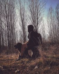 Man sitting on field in forest