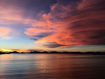 Scenic view of sea against dramatic sky during sunset