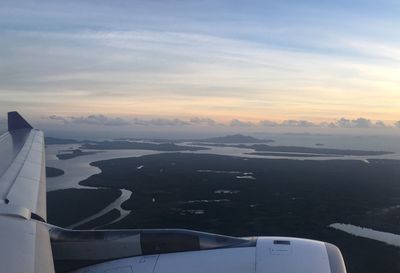 Airplane flying over landscape against sky