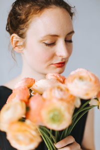 Close-up of young woman holding orange flowers