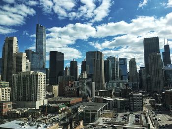 Aerial view of buildings in city against sky