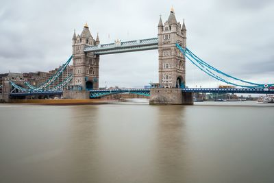 Tower bridge over thames river against sky in city