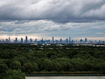 Bangkok city skyline as seen from the legume forest of suburban bang khun thian bangkok thailand