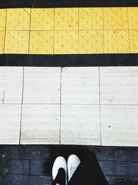 Low section of person standing on tiled floor