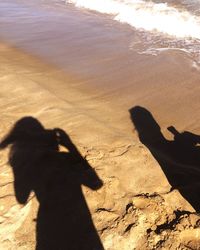 Shadow of man on sand at beach