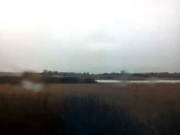 Scenic view of field against cloudy sky