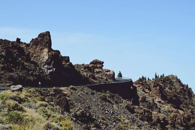 Scenic view of cliff with road against clear sky