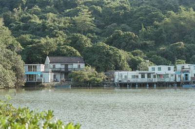 House by lake against trees and plants