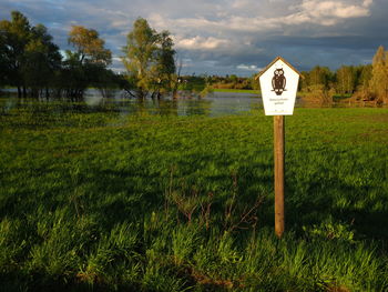 Information sign on wooden post in field