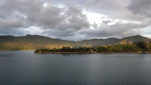 Scenic view of lake by mountains against sky