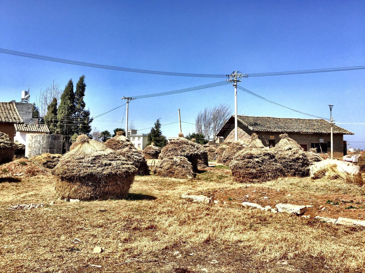 architecture, building exterior, built structure, clear sky, house, sky, roof, old, blue, low angle view, day, residential structure, sunlight, copy space, rural scene, outdoors, fuel and power generation, damaged, abandoned, stone wall