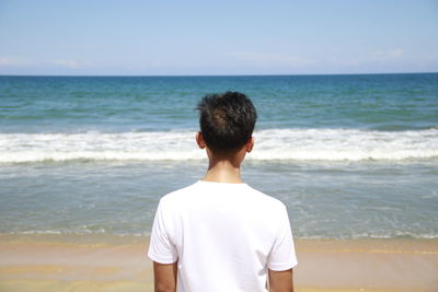 Rear view of man standing on beach