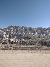 Rock formations on land against clear blue sky