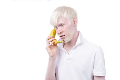 Portrait of man holding apple against white background