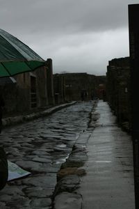 Walkway in city against sky