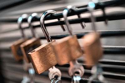 Close-up of padlocks hanging on railing 