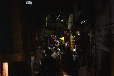 People in illuminated market at night