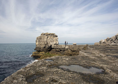 Rock formation on beach against sky