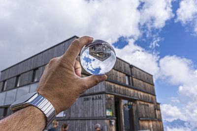 Man holding glass against sky