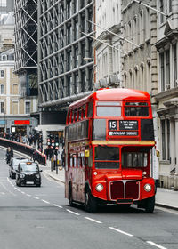 Red car on city street by buildings