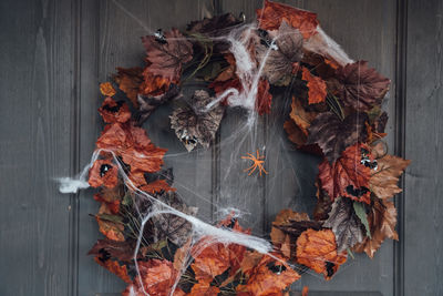 Close-up of dry autumn leaves on wood against wall