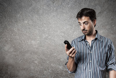 Portrait of man standing against wall