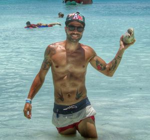 Portrait of shirtless man swimming in sea