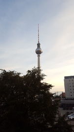 Low angle view of communications tower in city