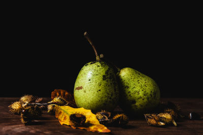 Close-up of fruits on table against black background