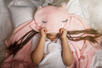 High angle view of girl sleeping on bed at home