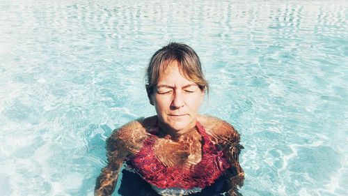 Portrait of young woman swimming in pool