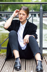 Young woman sitting on railing