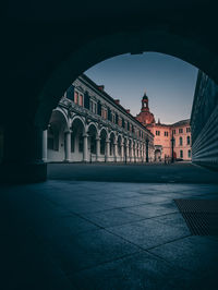 Historic building seen through arch in city during sunset