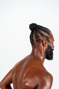 Low angle view of shirtless man standing against white background