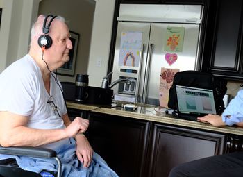 Senior male in wheelchair wearing headphones for hearing test