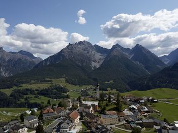 Scenic view of townscape and mountains against sky