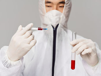 Doctor holding syringe and tube filled with blood