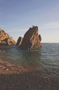 Scenic view of sea and cliff against sky