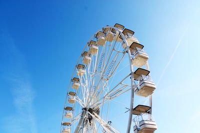 Low angle view of ferris wheel against clear blue sky